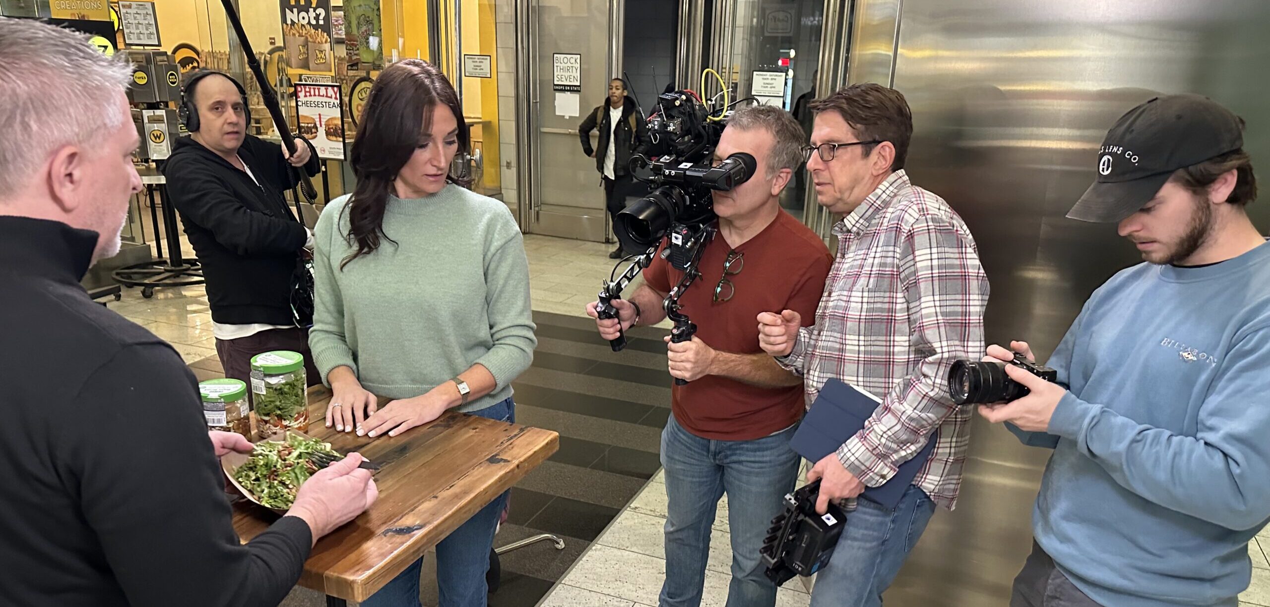 Behind-the-scenes look at a professional video crew filming a client testimonial interview, highlighting the importance of a skilled team to guide the process.